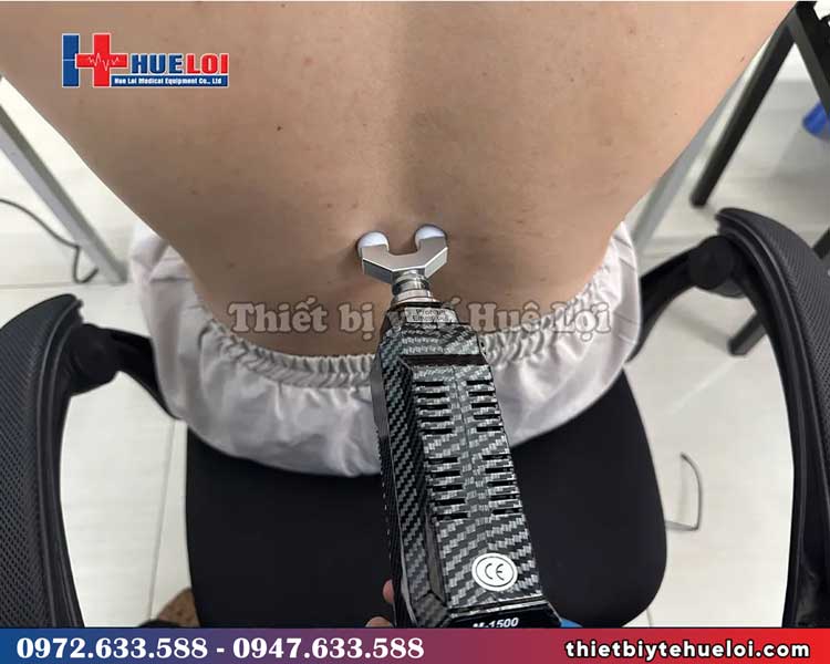 bệnh nhân trị liệu bằng súng bấm huyệt tác động cột sống 